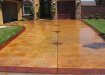 A driveway with a red border and a tan floor.