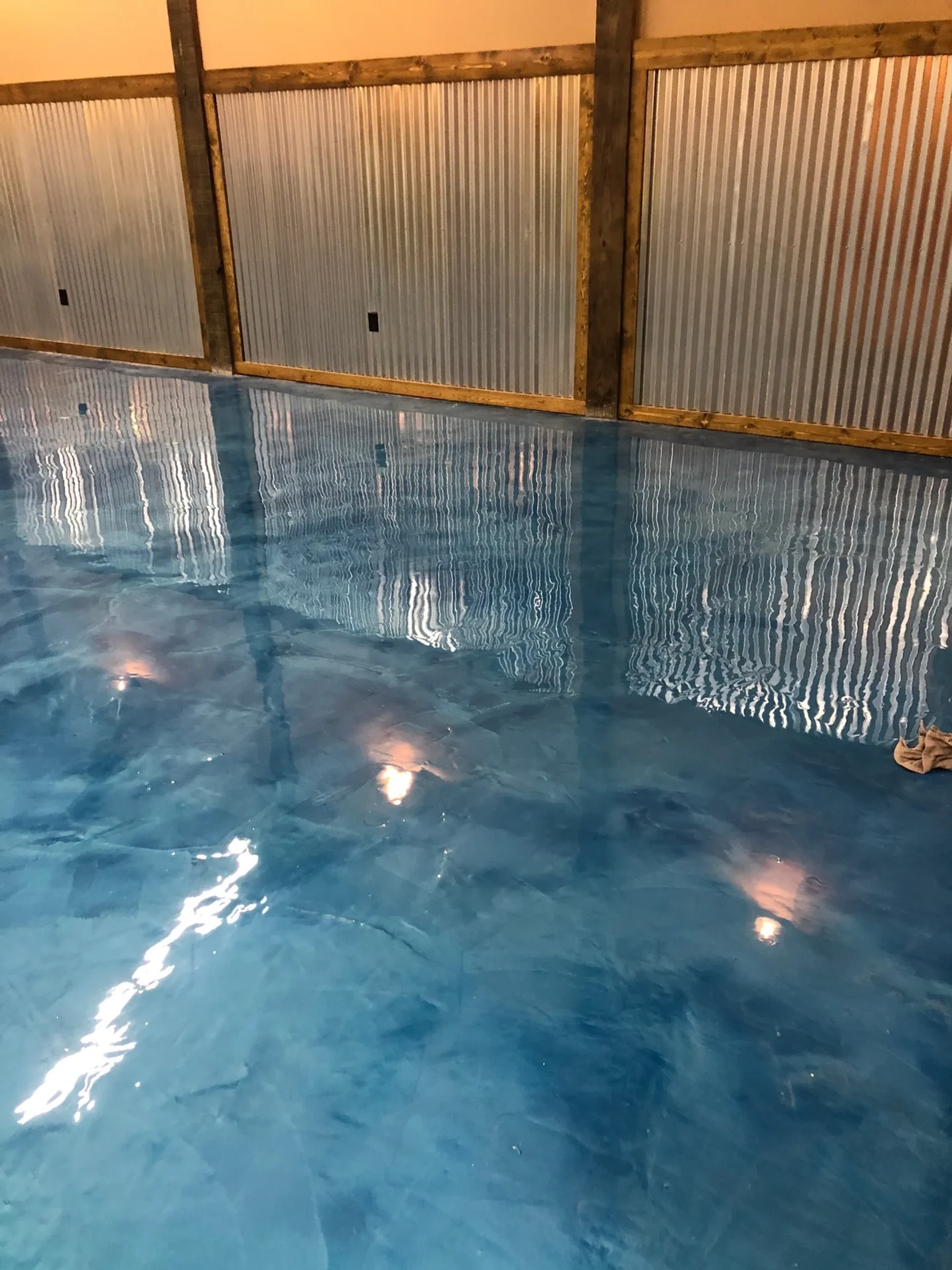 A pool with water on the ground and lights
